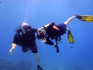 Family in action, father and son dive together scuba diving phuket